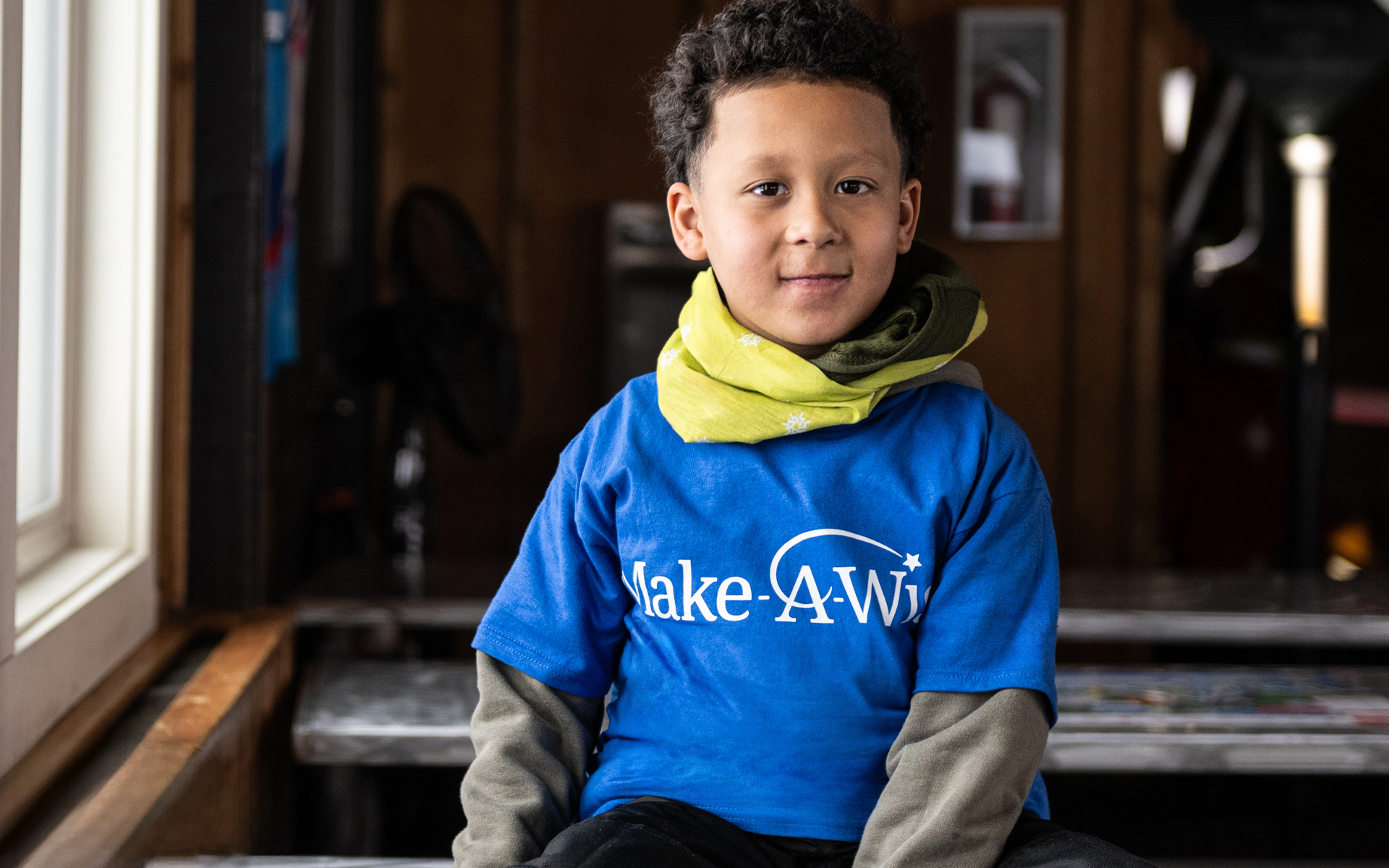 Boy in Make-A-Wish shirt with bandana.